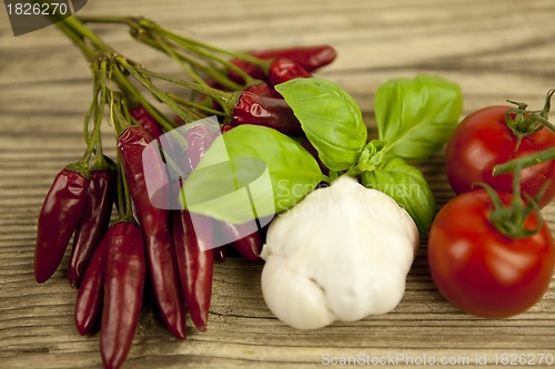 Image of red hot chilli pepper with basil and garlic on table