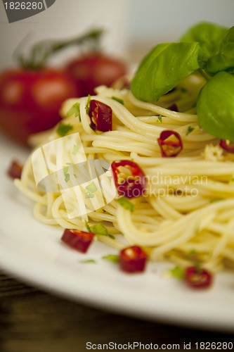 Image of fresh pasta with basil and red chilli on table