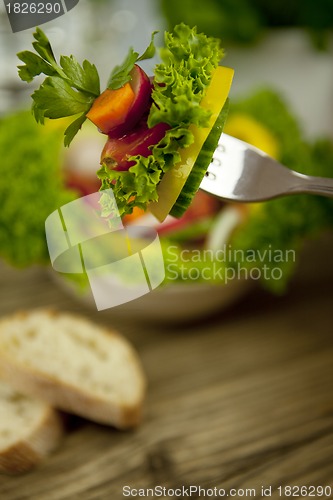 Image of fresh tasty healthy mixed salad and bread on table