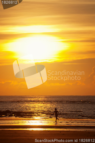 Image of Sunset on a beach with silhouette of a kid
