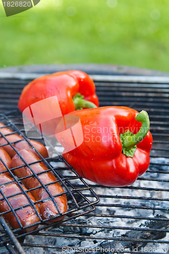 Image of Red sweet pepper and sausages on a grill