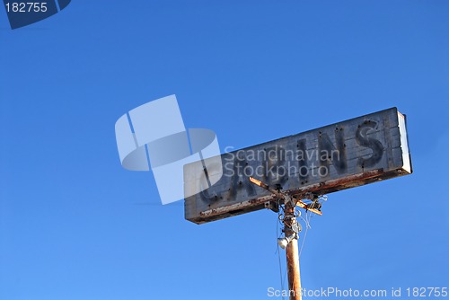 Image of Old weathered "Cabins" sign along a lonely highway
