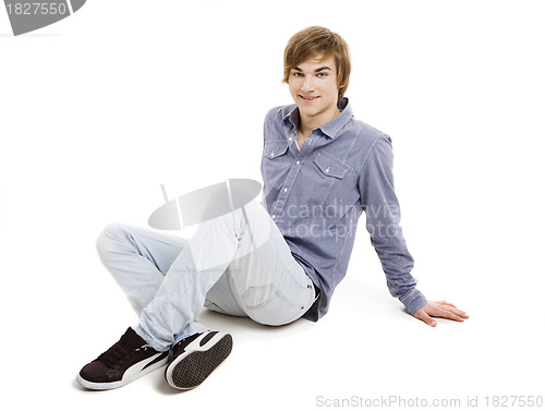 Image of Young man sitting on the floor