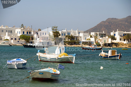 Image of Greek fishing boats with flag typical white block buildings Poll