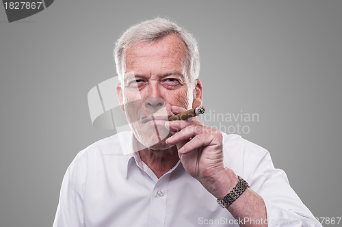 Image of Handsome senior smoking a cigar