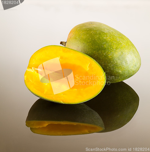 Image of Two mangoes on reflecting surface