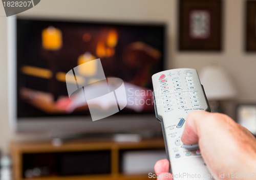 Image of Close up of TV remote control with television
