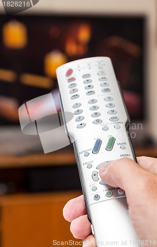 Image of Close up of TV remote control with television