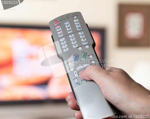 Image of Close up of TV remote control with television