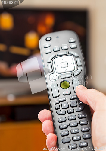 Image of Close up of TV remote control with television