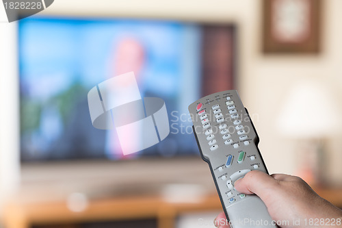 Image of Close up of TV remote control with television