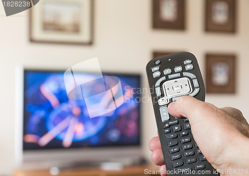 Image of Close up of TV remote control with television