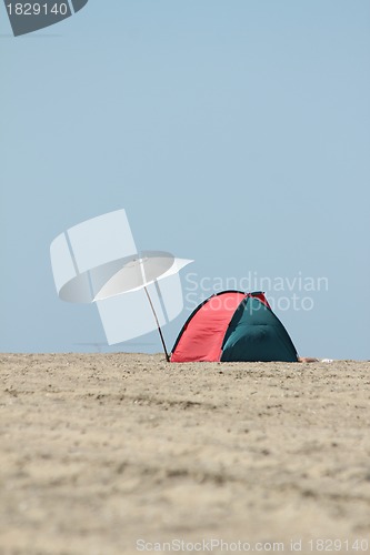 Image of lonely parasol and sun tent on the beach