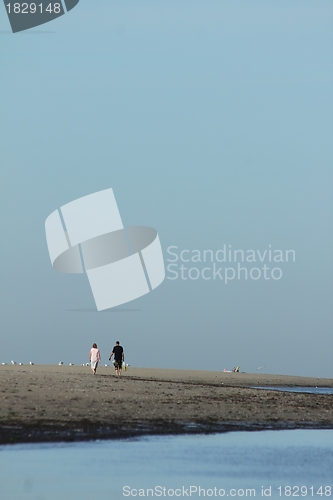 Image of couple walking at the shoreline