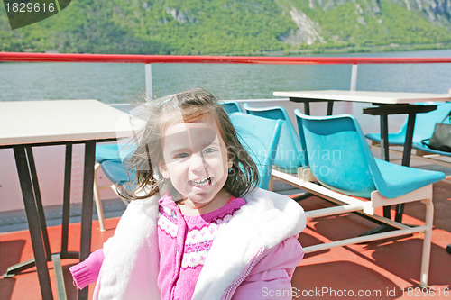Image of playful pretty little girl on sail boat in Lugano