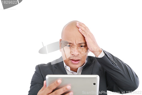 Image of Shocked young business man with a tablet isolated on the white 