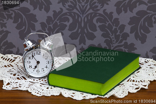 Image of Retro alarm clock and green book