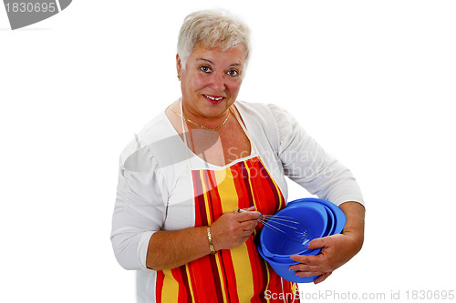 Image of Female senior housewife with bowls and eggbeater