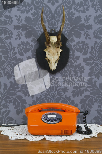 Image of Retro communication on floral wallpaper and antler