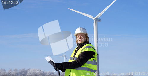 Image of engineer or architect with white safety hat and wind turbines on