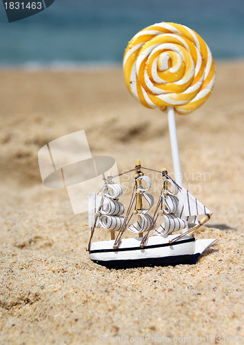 Image of Small toy sailing ship on the beach 