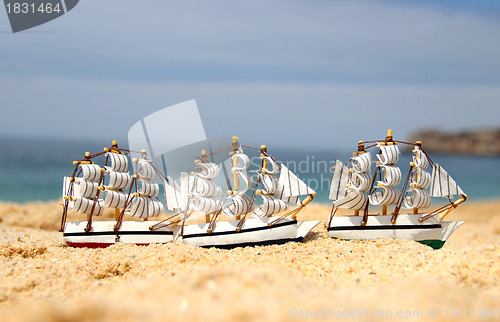 Image of Funny small toy sailing ships on the beach 