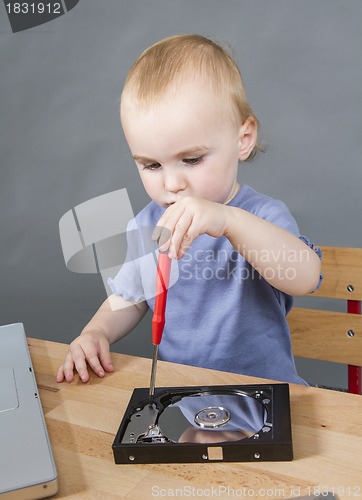 Image of young child working at open hard drive