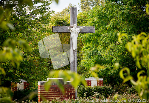 Image of Statue of Jesus on cross in wooded garden