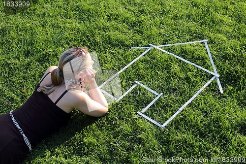 Image of Woman dreaming from a house in a meadow