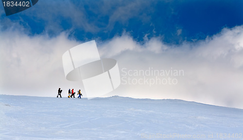 Image of Four snowboarders go up the hill