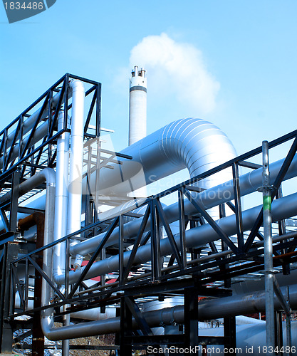 Image of industrial pipelines and smokestack with a natural blue backgrou