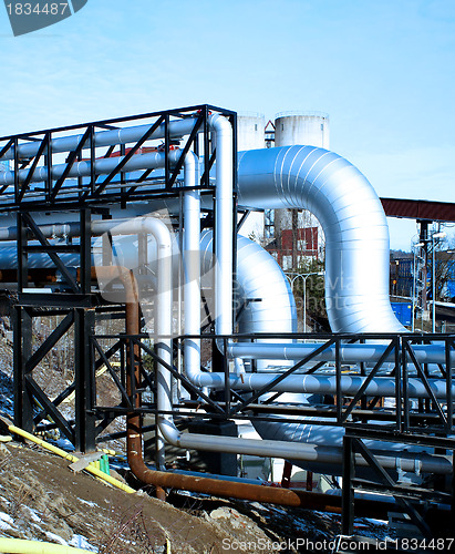 Image of industrial pipelines with insulation against natural blue backgr