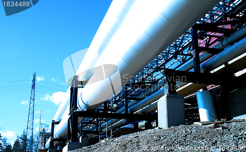 Image of industrial pipelines with insulation against natural blue backgr