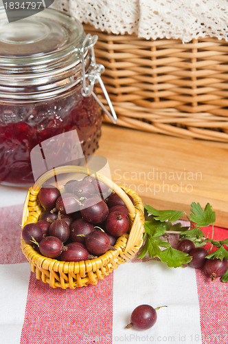 Image of Basket with berries of a red gooseberry and jam