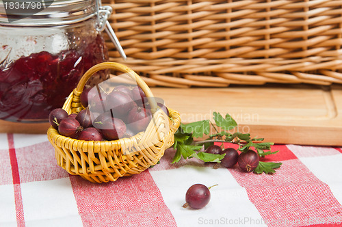 Image of Basket with berries of a red gooseberry and jam