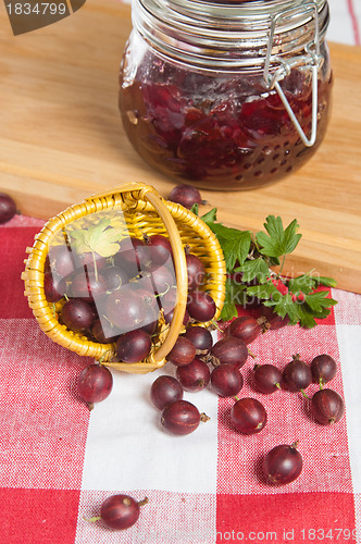 Image of Basket with berries of a red gooseberry and jam