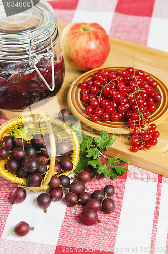 Image of Jam with berries of red currant and gooseberry on the table