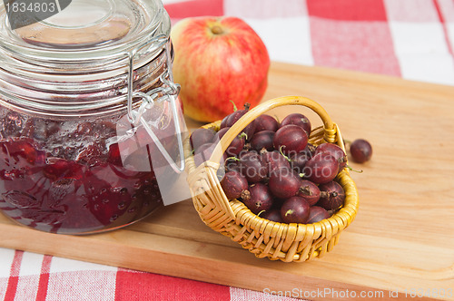 Image of Basket with berries of a red gooseberry and jam