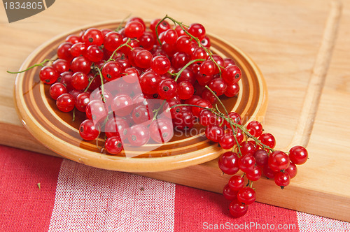 Image of Berries of a red currant in a plate on a table