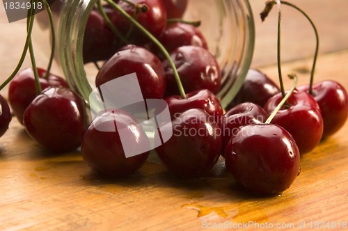 Image of Cherry in glass jar isolated on the wooden background