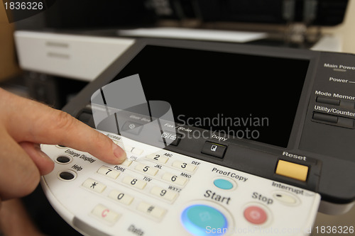 Image of Finger pressing of keyboard buttons of the laser copier