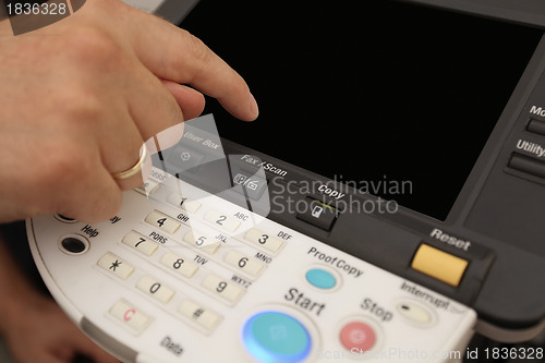 Image of Finger pressing of keyboard buttons of the laser copier