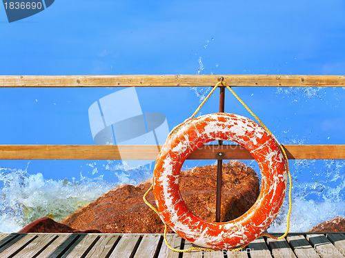 Image of sea and pier with life buoy