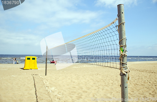 Image of Volleyball net sea waste bin boat people relax 