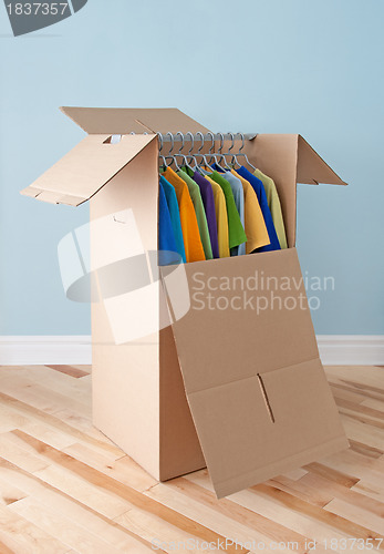 Image of Wardrobe box with colorful clothing, ready for moving