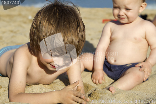 Image of Brother and baby girl sister enjoying beach