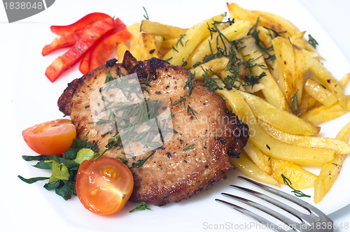 Image of Grilled pork steak on white plate.