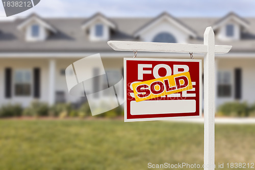 Image of Red Sold For Sale Real Estate Sign and House