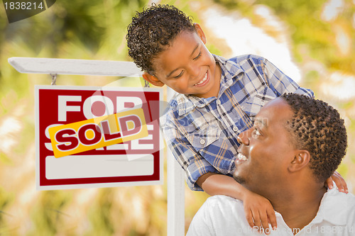 Image of Mixed Race Father and Son In Front of Sold Real Estate Sign