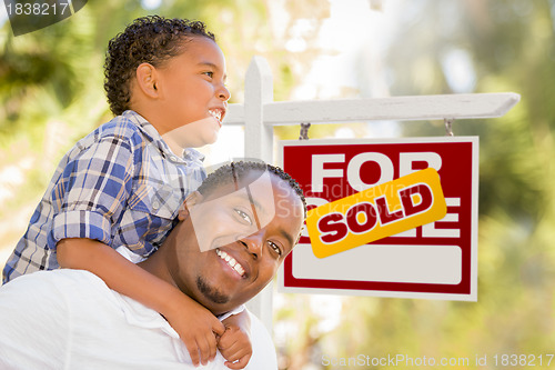 Image of Mixed Race Father and Son In Front of Sold Real Estate Sign